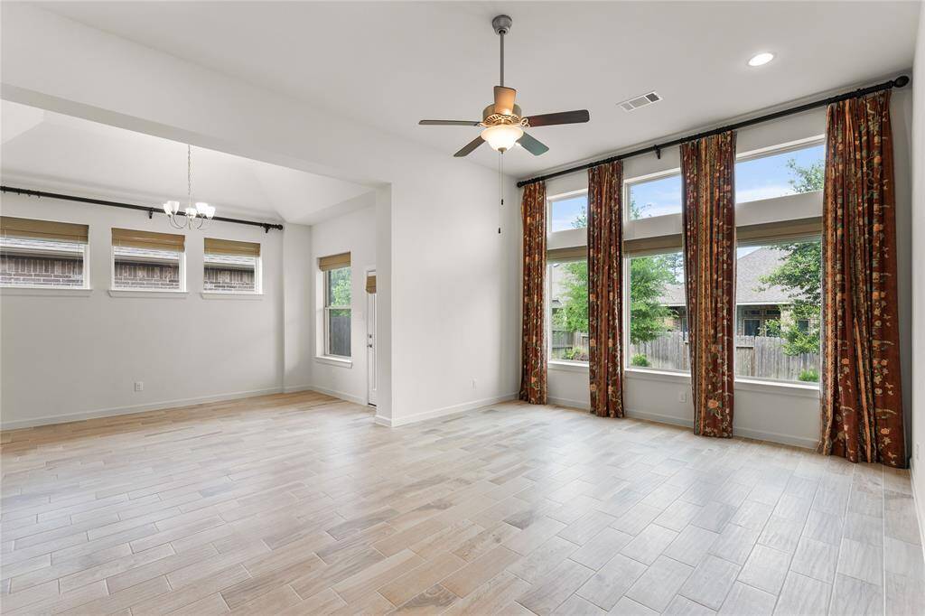 Bright, open living room with wood-look tile floors and abundant natural light.