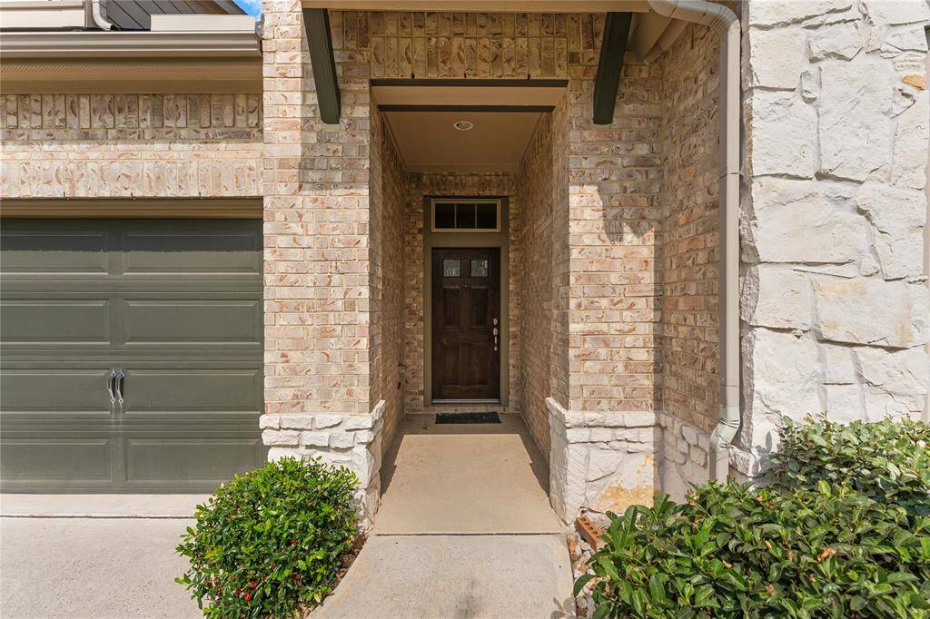 Covered front entry with stone and brick accents offers a warm welcome.