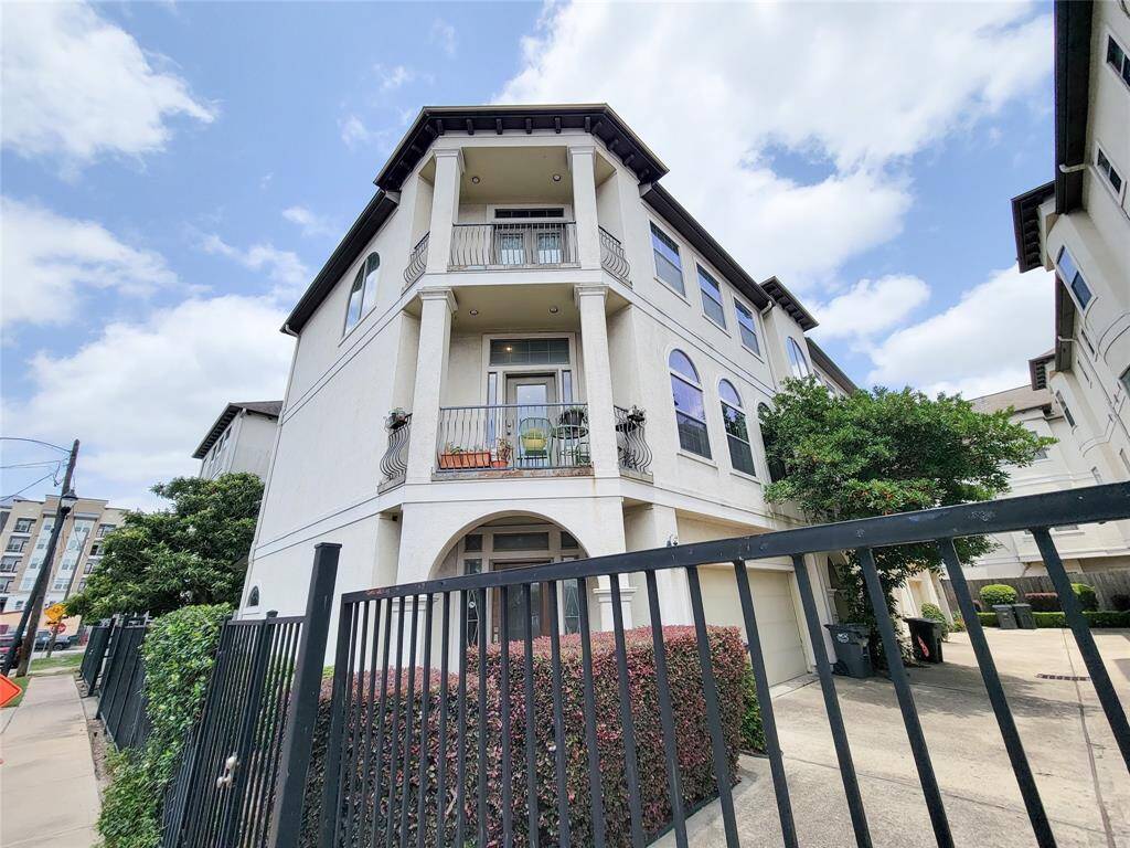 This is a modern, 3 story townhouse (end unit) with a stucco exterior, and features a gated entrance and driveway, offering a mix of privacy and urban convenience.