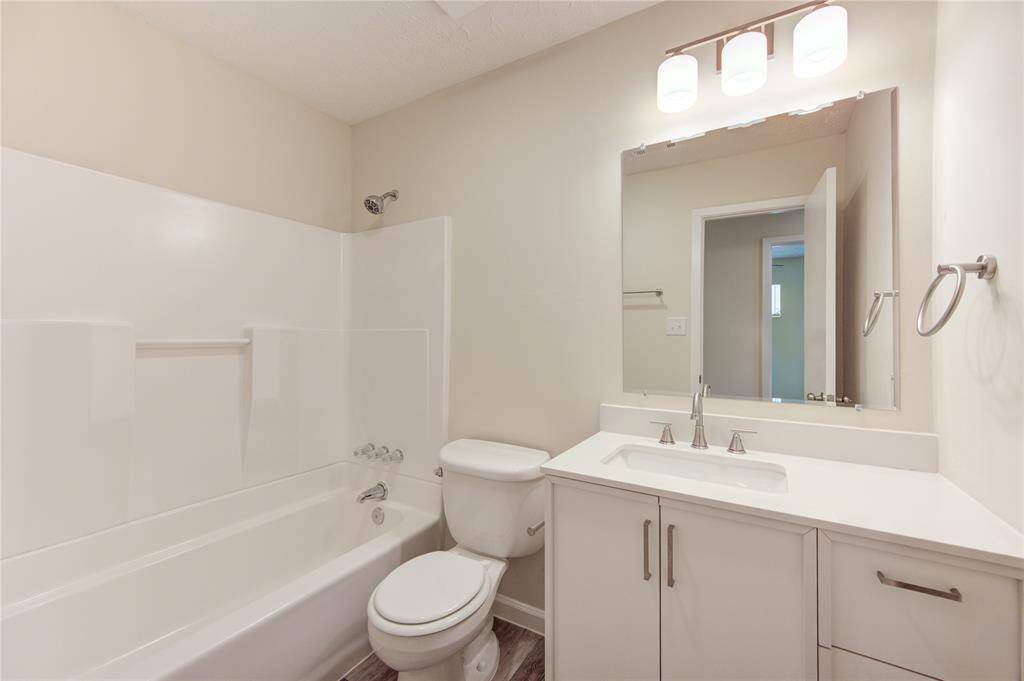 Secondary bath.  All bathrooms have new vanity cabinets with counters, new sinks and faucets, new mirrors and light fixtures and new towel bars and cabinet hardware!