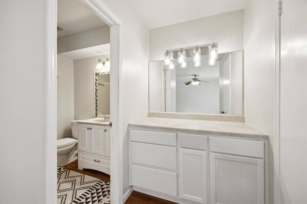 This ensuite bathroom features a well-lit bathroom and ample countertop space with lots of storage space. It includes a separate shower and washroom and modern light fixtures, offering a clean and functional design.