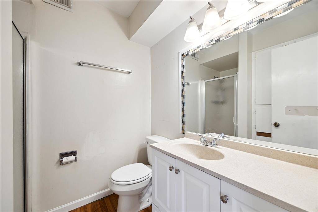This bathroom features a clean, modern design with a spacious countertop, large mirror, and bright lighting. It includes a shower with a glass door and has a neutral color palette, creating a fresh and inviting atmosphere.