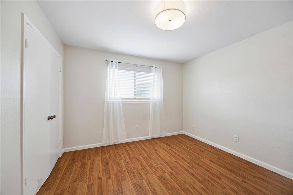 Another bedroom, which could also serve as a guest room or perhaps a home office. The walls are painted a neutral color, providing a blank canvas for your personal touch.