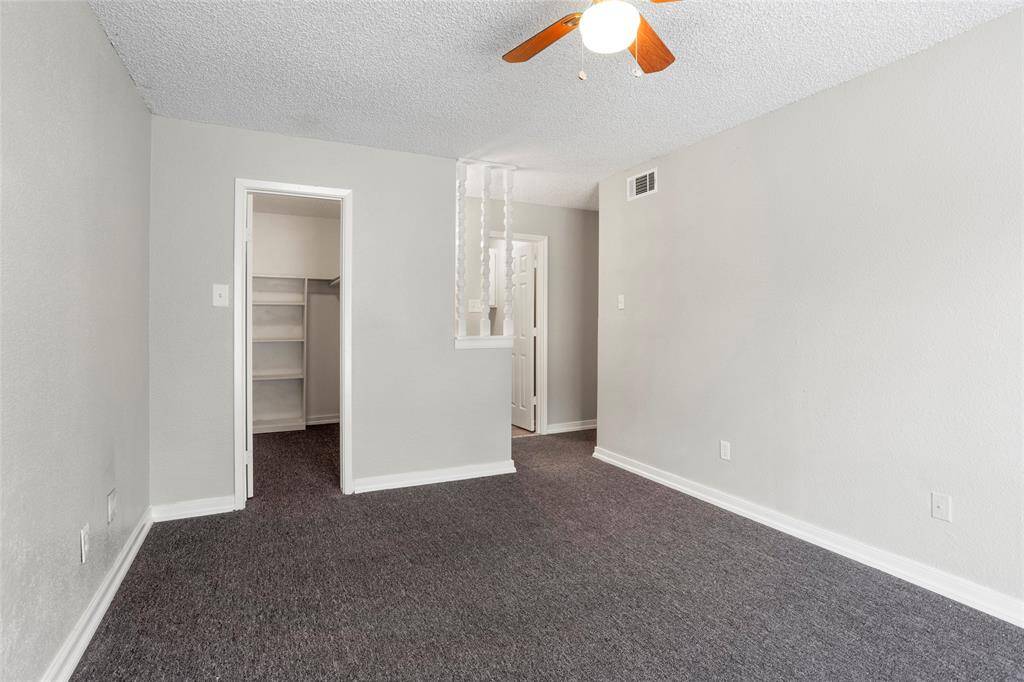 Opposite view of the primary bedroom, looking into the walk-in closet and vanity area.