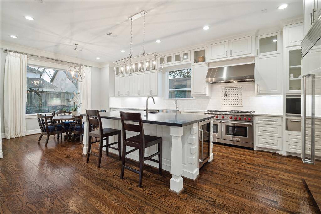 This gourmet kitchen is a chef’s dream starting with the oversized island which features a breakfast bar and prep sink.  The stainless-steel appliances include a Wolf 6-burner gas range with double ovens and pot filler, Wolf vent hood, built-in Sub-zero refrigerator, Wolf microwave and warming drawer, and Bosch dishwasher. A butler’s pantry and walk-in pantry with custom cabinets and counter space complete this fabulous kitchen.