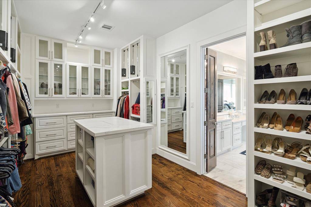 The walk-in closet was thoughtfully designed with amazing hanging space, custom built-ins, and an island with additional storage.