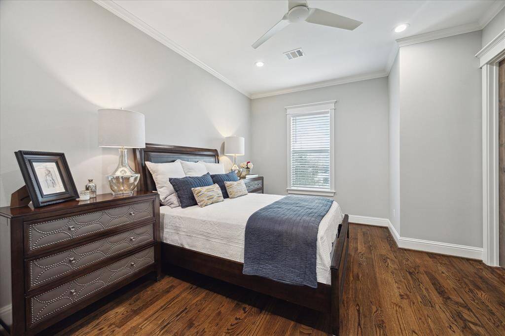 Guest Bedroom 1 - This guest bedroom is located off the front of the home and features hardwood floors, recessed lighting, ceiling fan, crown molding, a walk-in closet, and an ensuite bath.