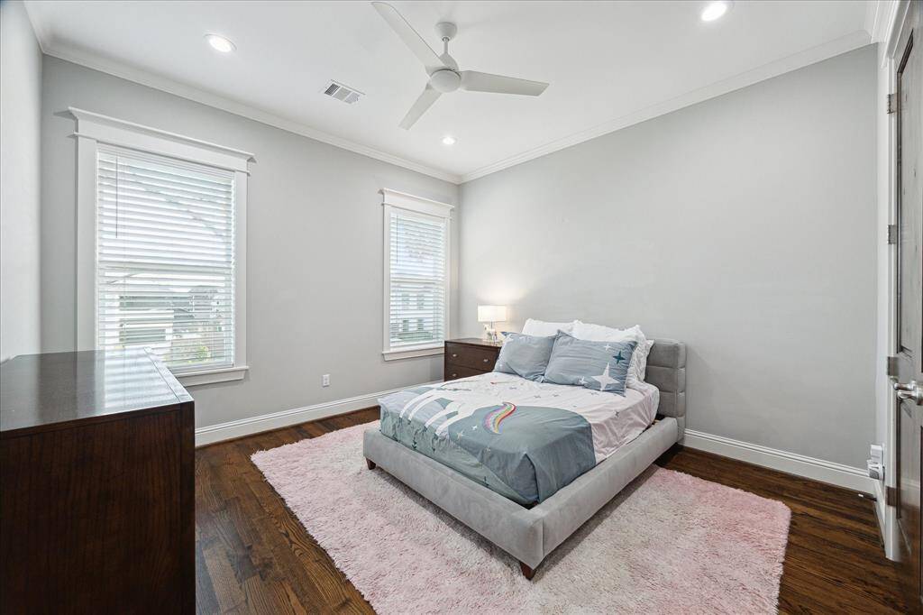 Guest Bedroom 2 - This guest bedroom is located off the front of the home and features hardwood floors, recessed lighting, ceiling fan, crown molding, a walk-in closet, and an ensuite bath.