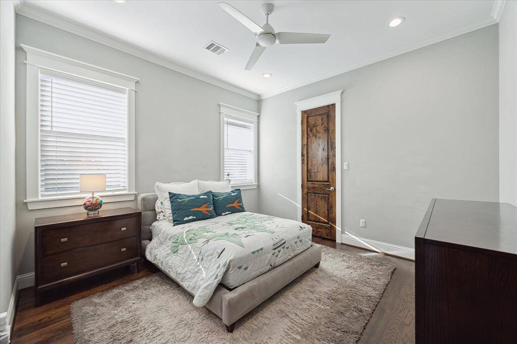 Guest Bedroom 3 - This guest bedroom is located off the side of the home and features hardwood floors, recessed lighting, ceiling fan, crown molding, a walk-in closet, and an ensuite bath.