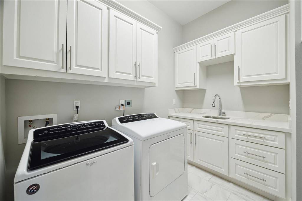 This spacious laundry room, conveniently located on the second floor, will not disappoint. Great storage, a sink, and counter space are wonderful features.