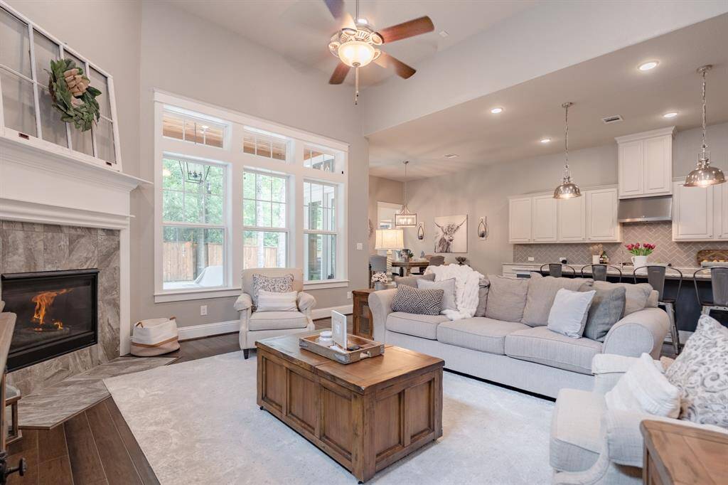 Spacious living area featuring a cozy corner fireplace, abundant natural light, and seamless connection to the kitchen and back porch.