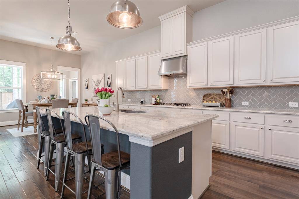 Beautifully designed kitchen featuring quartz counters, a premium sink upgrade, and spacious bar seating for casual dining.