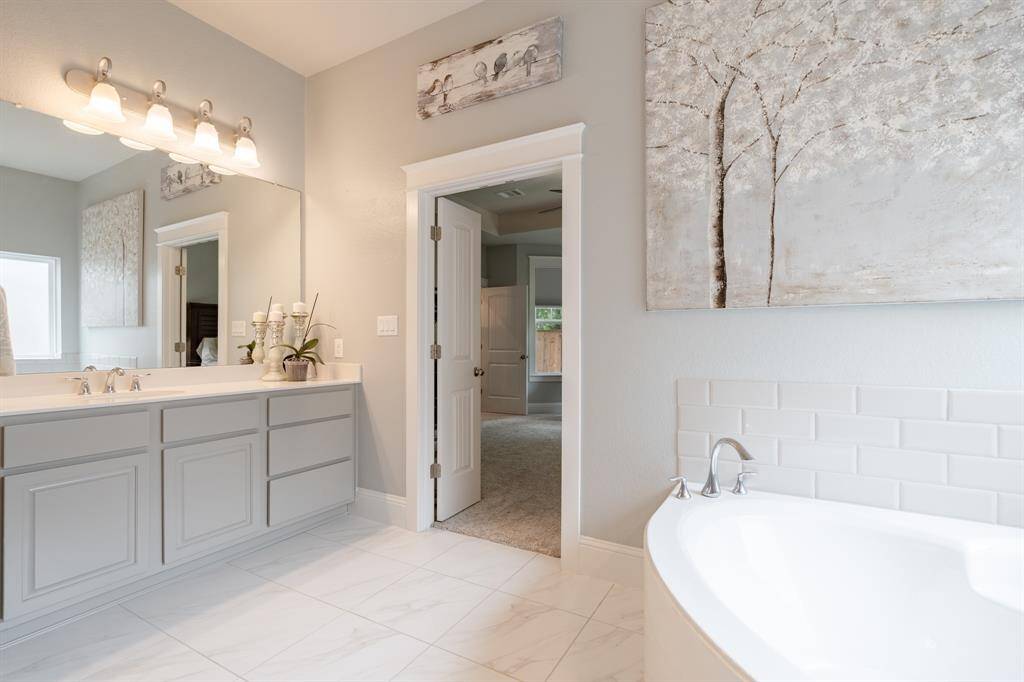 Spa-inspired primary bathroom featuring an extended walk-in shower, oversized soaking tub, and dual vanities