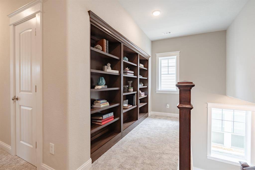 At the top of the stairs, a stunning built-in bookcase adds both charm and function—perfect for displaying books, decor, or family treasures.