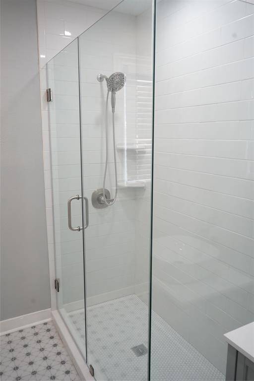 Stylish updated bathroom with floor to ceiling tile in the shower.