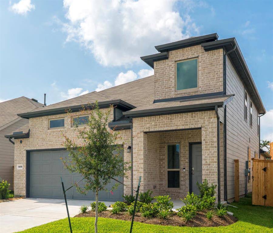 Welcoming covered front entry with landscaped walkway