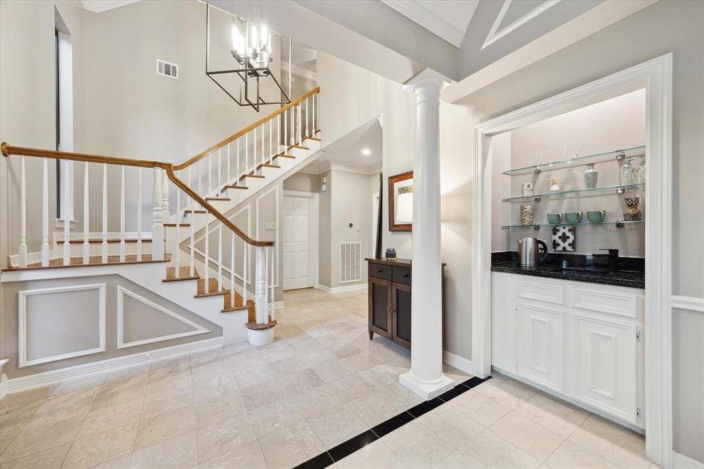This area offers soft, neutral tones, updated lighting, and a wet bar/display area.