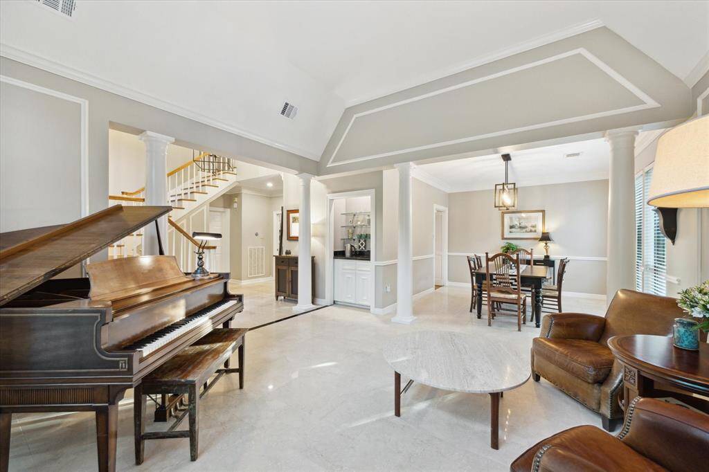The formal living room opens to the dining room.  These areas offer classic architectural details like columns and crown molding.