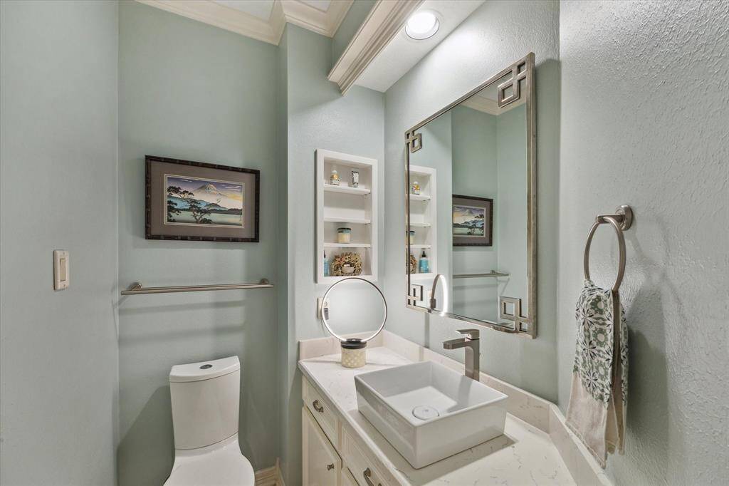 Tucked around the corner is this pretty powder room with its built-in shelves and updated finishes.