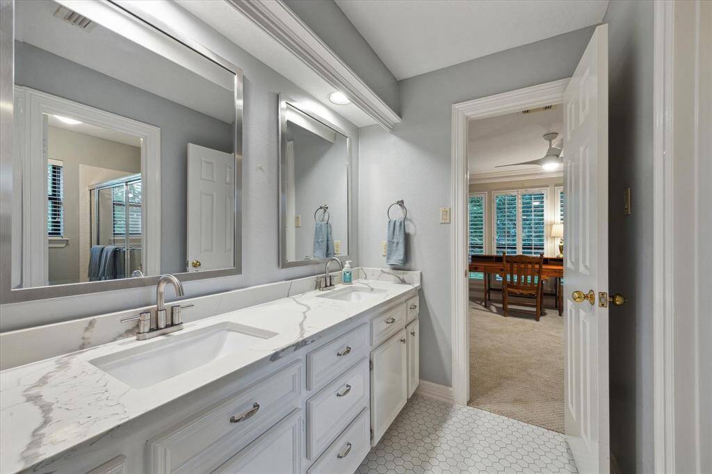 All bathrooms have been updated. This one offers pretty quartz countertops, double sinks, updated hardware and lighting and framed mirrors.