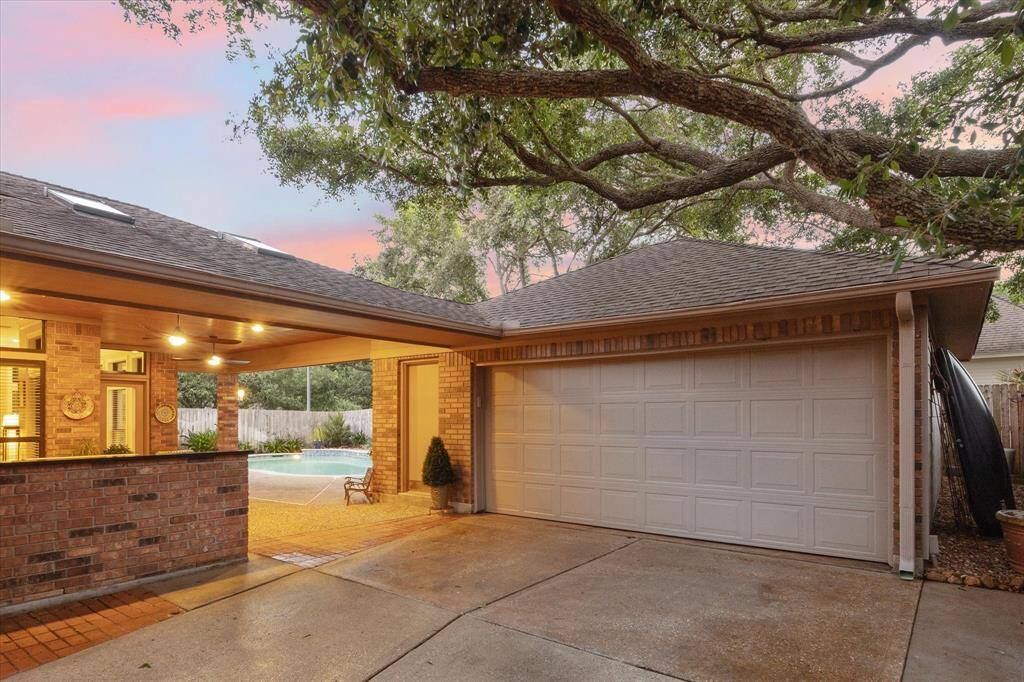 Even the driveway area is made for fun! It's open to the outdoor kitchen and covered patio. Mature trees provide shade and an attractive backdrop, too.