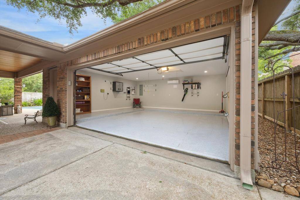The thoughtful details extend to the garage, too. This space features its own AC, an insulated garage door, an epoxy floor coating, and a shelving unit for storage. Through the pull-down door, you'll also find one of four attic areas this home offers.