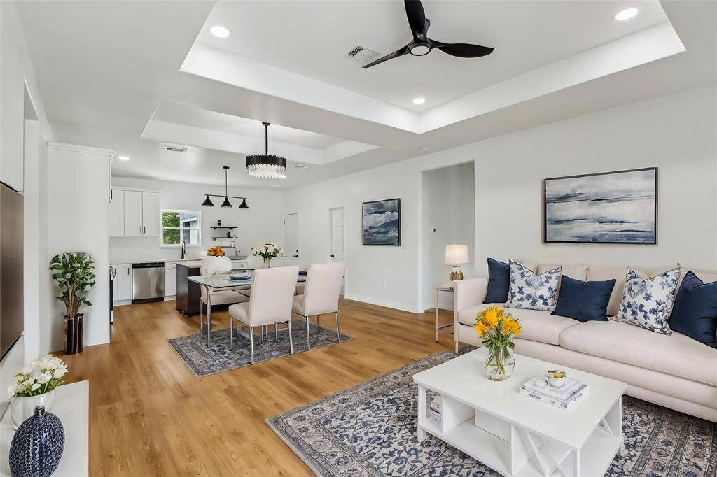 This open-concept living space seamlessly blends the living room, dining area, and kitchen, creating an expansive and inviting environment perfect for everyday living and entertaining.
