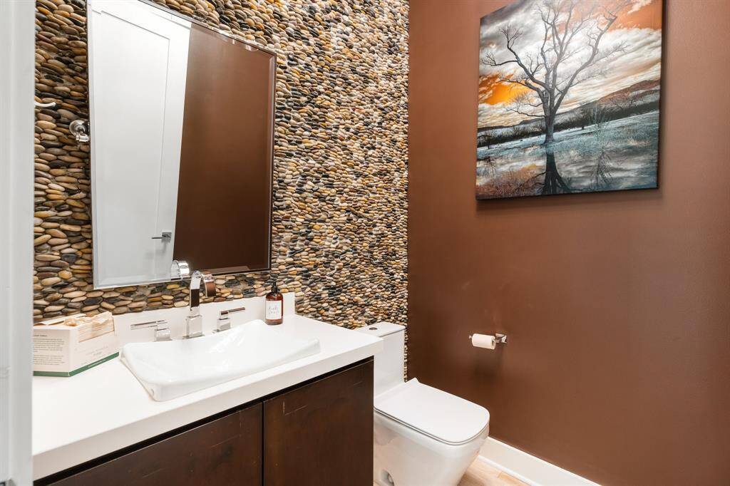 Guest powder room has a dramatic stone wall.