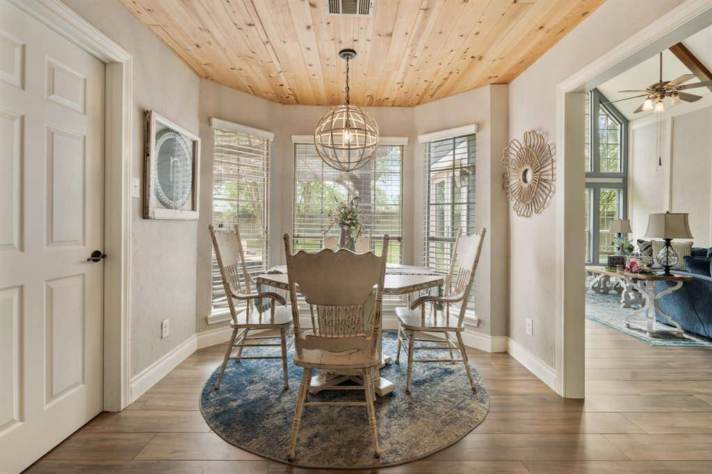 Start your day off right with a cup of coffee sitting with your family in the breakfast area! Featuring a large bay window, neutral paint, accent wood ceiling beautiful flooring, and custom lighting.