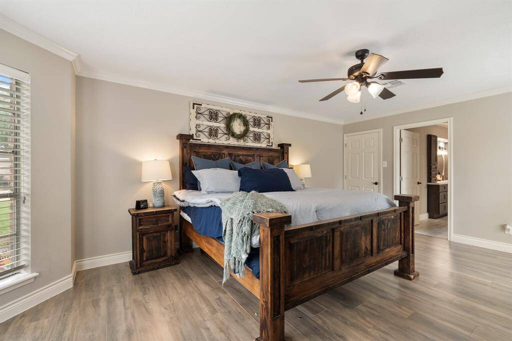 What a wonderful place to come home to! This stunning primary suite greets you with neutral paint, crown molding, a ceiling fan, wood look tile flooring, and direct access to the ensuite bathroom!