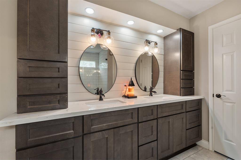 You'll love getting ready in this updated bathroom! It includes a large vanity with dual sinks, quartz countertops, new wood cabinets, framed mirrors, recessed lighting, and accent wall.