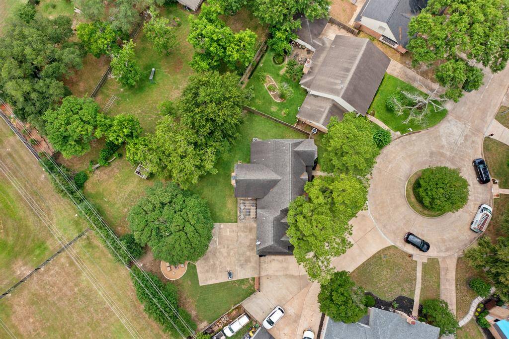 This sweeping aerial shot highlights the oversized lot, beautifully landscaped backyard, featuring custom landscaping, fire pit, pergola, and plenty of green space to enjoy!