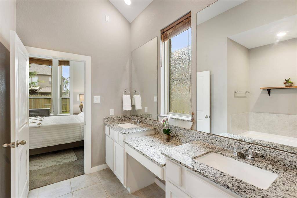 The primary suite offers a spa-like bathroom with double under mounted sinks, granite countertops and vanity area.