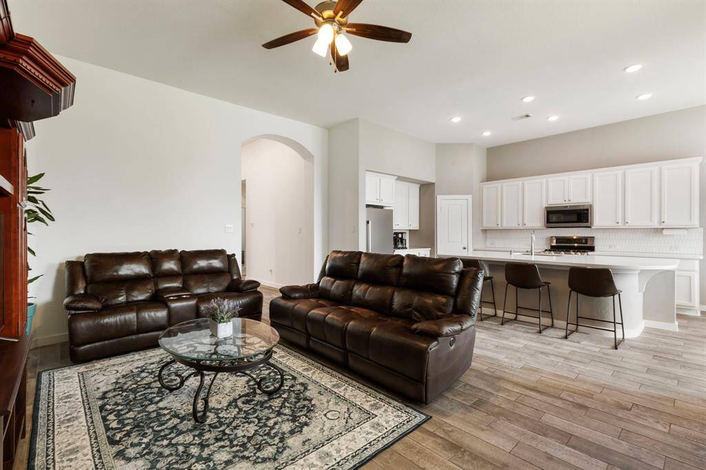 The warm wood-like tile flooring continues into the spacious family room and kitchen area.