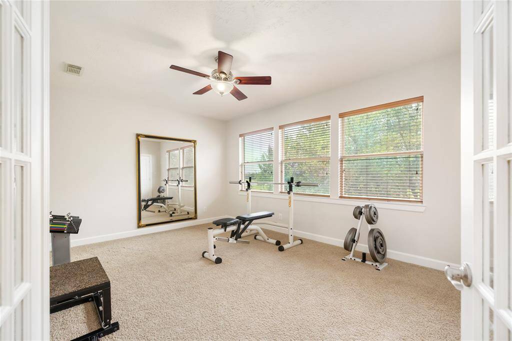 This spacious upstairs flex room offers endless possibilities—use it as a fifth bedroom, home gym, playroom, or second office. With large windows showcasing peaceful lake views, plush carpeting, and a ceiling fan, it’s a bright and versatile space ready to suit your lifestyle.
