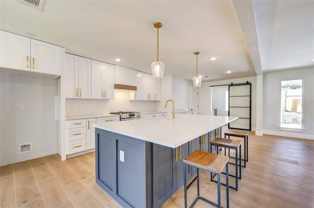 A generous center island anchors the kitchen, complete with additional cabinet storage and breakfast bar seating—perfect for casual dining, entertaining, or homework time.