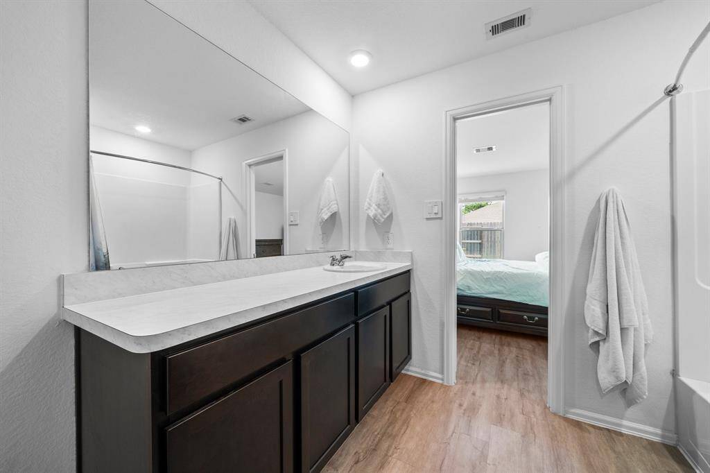 The primary bathroom features a single sink vanity and a tub-shower combo, combining comfort and practicality.
