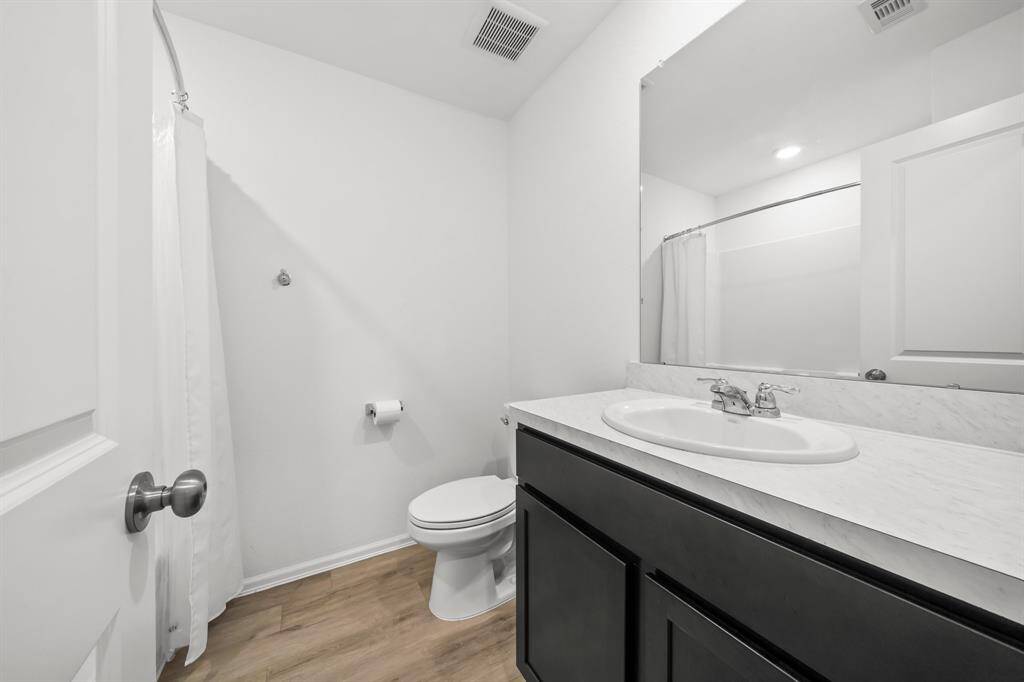 The full bathroom includes a toilet in an open layout, not enclosed in a separate stall.Functional and accessible, it offers a straightforward and efficient design.