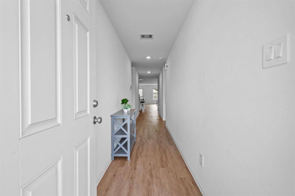 The home features a hallway-style entry with bright white walls, offering a clean and inviting first impression.