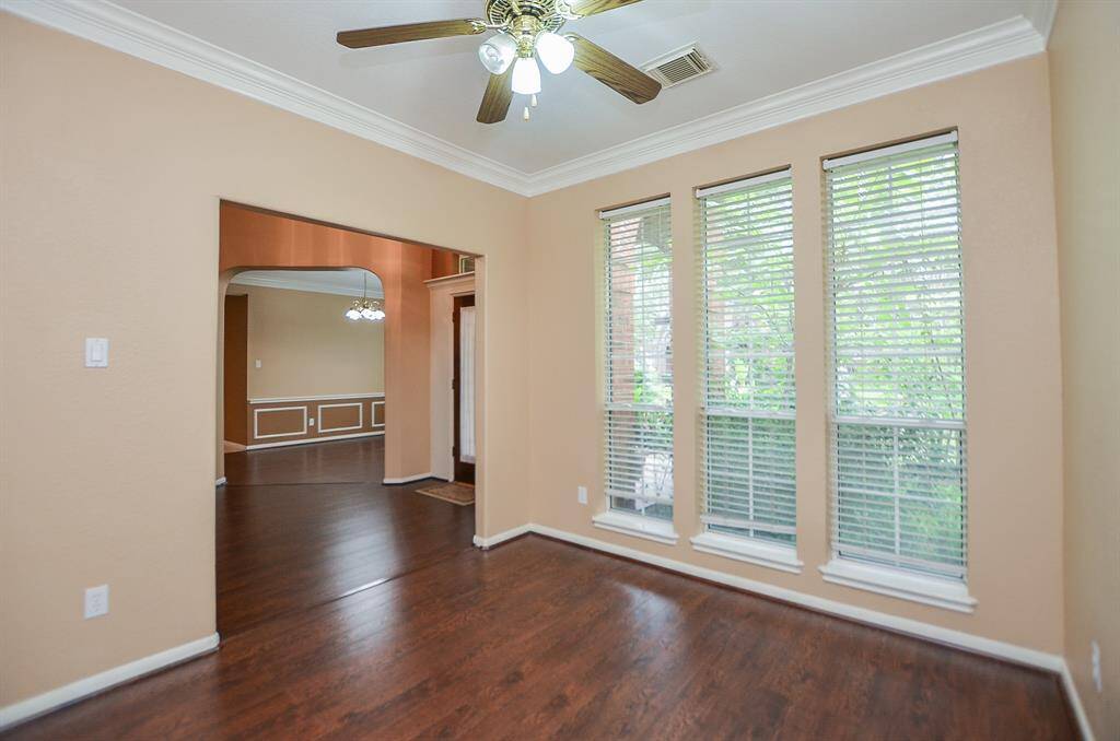 This elegant front room, just off the main hallway/foyer, with triple floor-to-ceiling windows, is perfect as a study/home office.