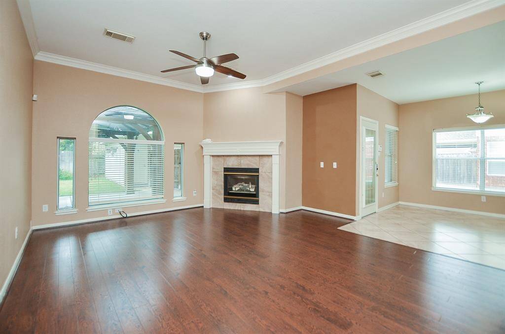 A vaulted ceiling embraces the warm hardwood floor, large arched window and the star of the show, a built-in, stone encased gas fireplace to warm spirits in any season. Can you picture this divine space decked out for the holidays? The window lined area, right, is perfect for your breakfast/casual dining nook.