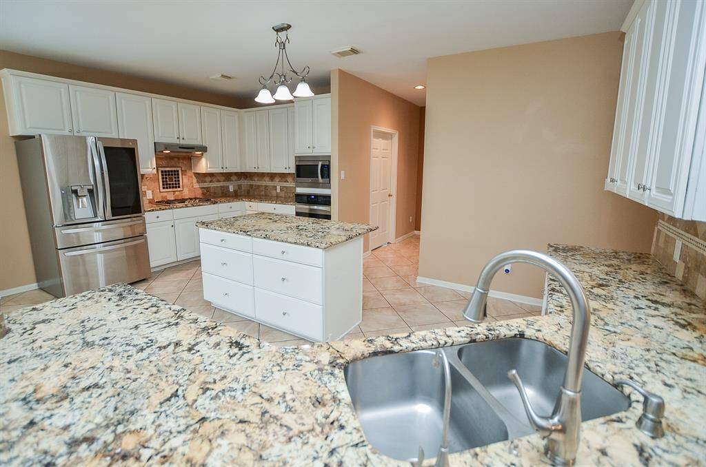 Shining stainless steel appliances add to the glow of this bright kitchen!