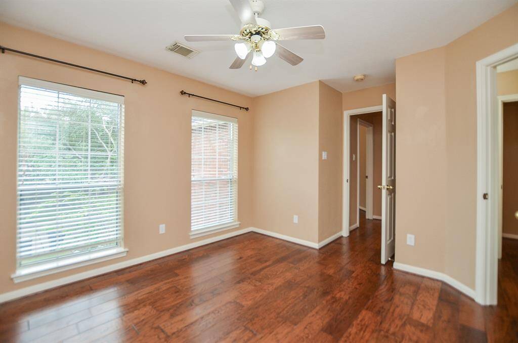 Grand double windows brighten this spacious secondary bedroom.