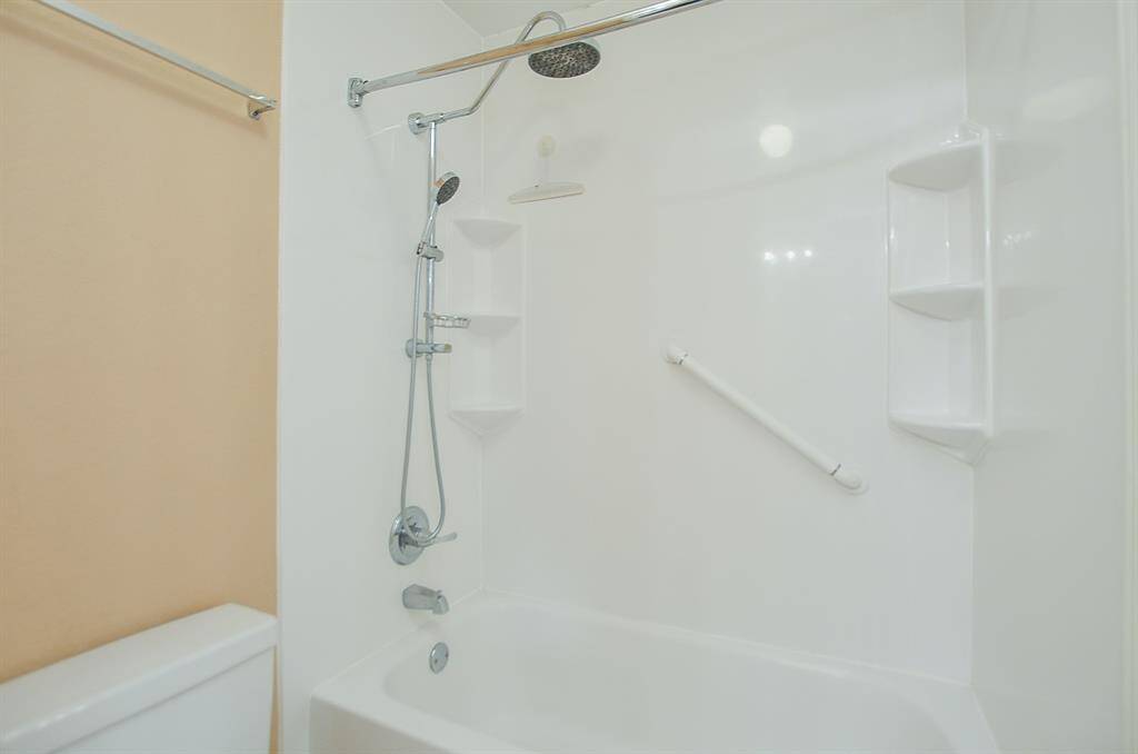 This sparkling white combined bathtub/shower in a secondary bath offers quick options!