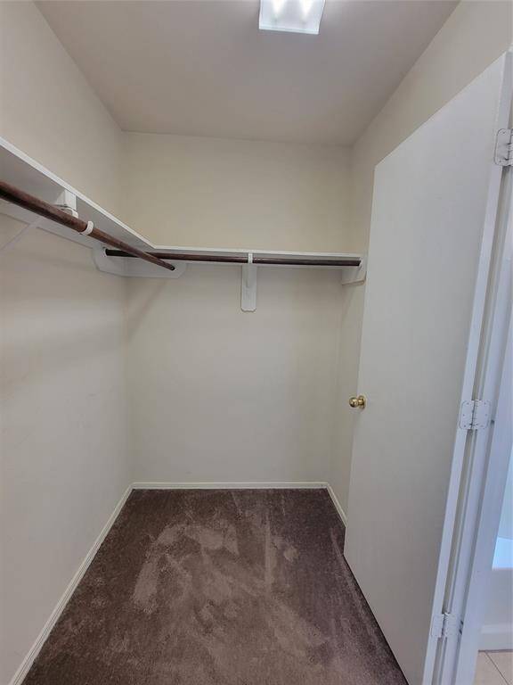 Spacious walk-in closet with ample shelving, perfect for an organized wardrobe and additional storage needs.