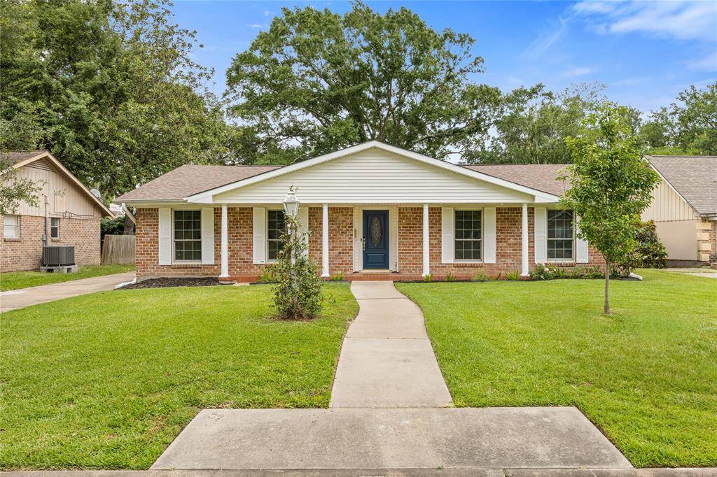 Front Elevation – Full View of Brick Ranch-Style HomeClassic curb appeal with clean landscaping, a wide driveway, updated roof, and symmetrical columned porch. Showcases the home’s timeless design in the heart of Nassau Bay.