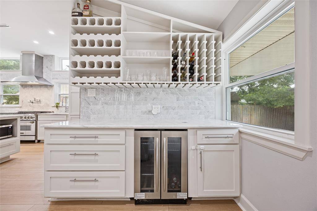 Marble-Topped Beverage Bar with Upper and Lower Built-In StorageWall-to-wall bar with soft-close cabinetry, floating glass holders, and marble tile backsplash. Ideal for cocktail nights and guest gatherings.