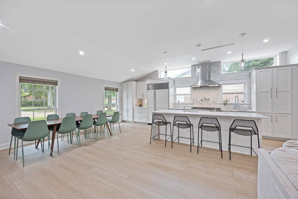 Spacious Open-Concept Kitchen and Dining Area with Vaulted CeilingsThis image showcases seamless flow from the designer kitchen to the light-filled dining area, with large windows and modern finishes throughout.