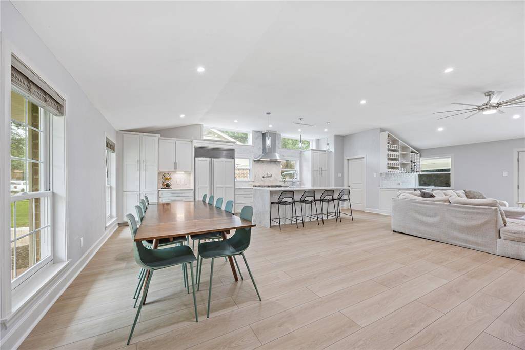 Open Concept Living, Kitchen & Dining AreaVaulted ceilings and wide-plank waterproof flooring enhance this seamless open layout. Showcases the custom kitchen, bar area, and bright living space in one frame.