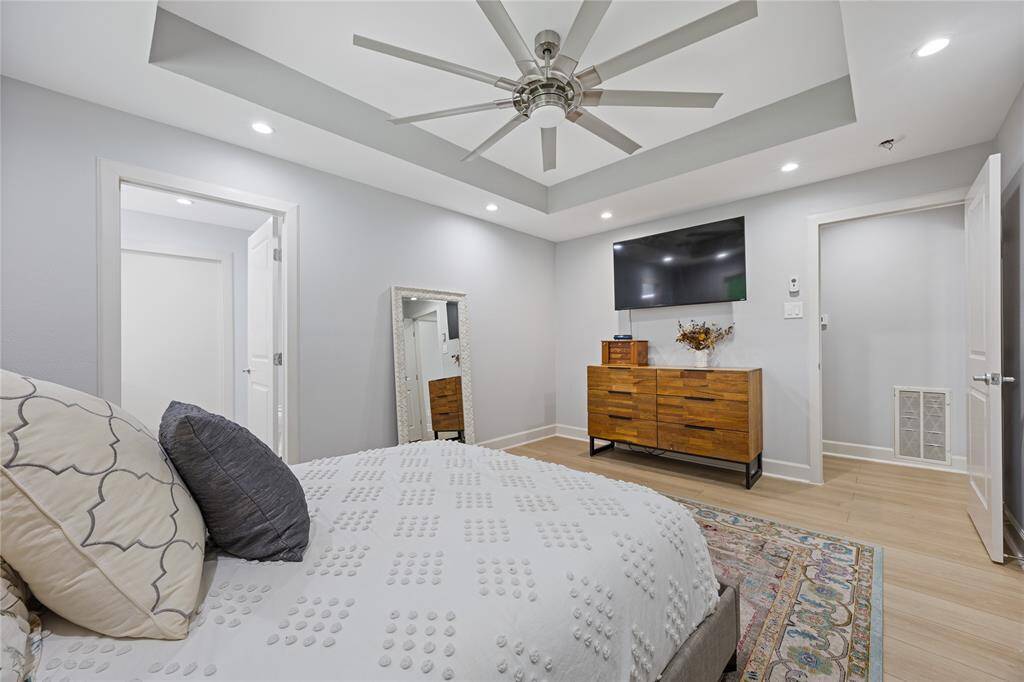 Second View of Primary with Double Door Entry to EnsuiteTray ceiling with inset lighting continues throughout this owner’s suite, with a soft color palette and elegant design transitions.